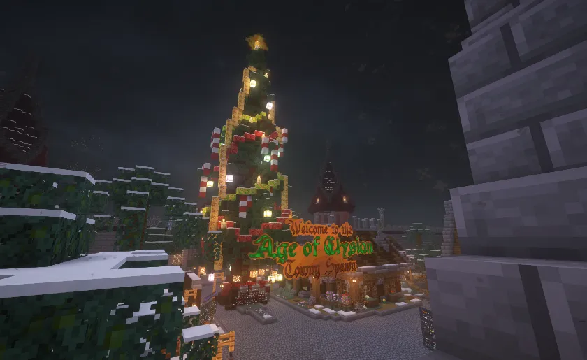 A snowy village at night with a brightly lit Christmas tree and festive buildings